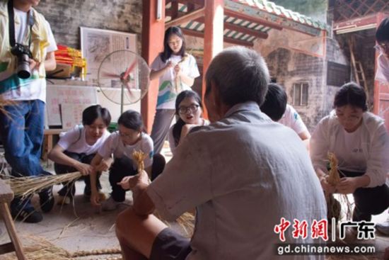  调研组成员学习草龙制作细节过程。刘泽 供图